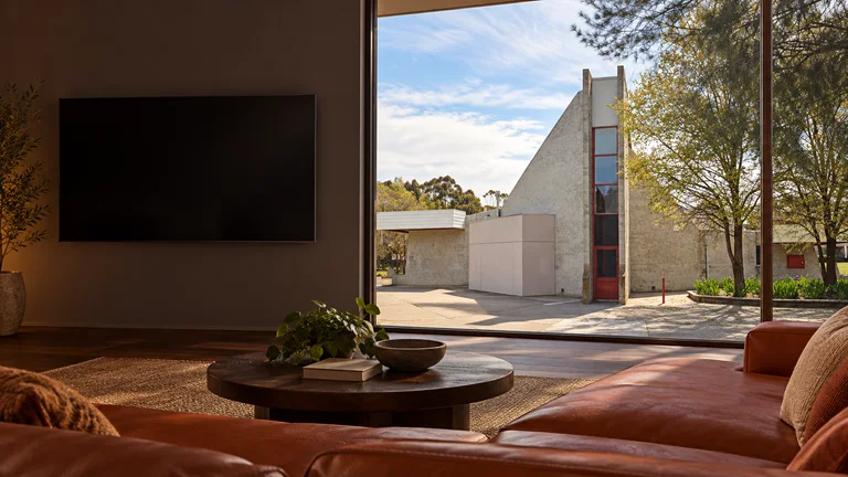 Giralang — Room concept with a wall-mounted TV and a view inspired by Giralang Primary School architecture.